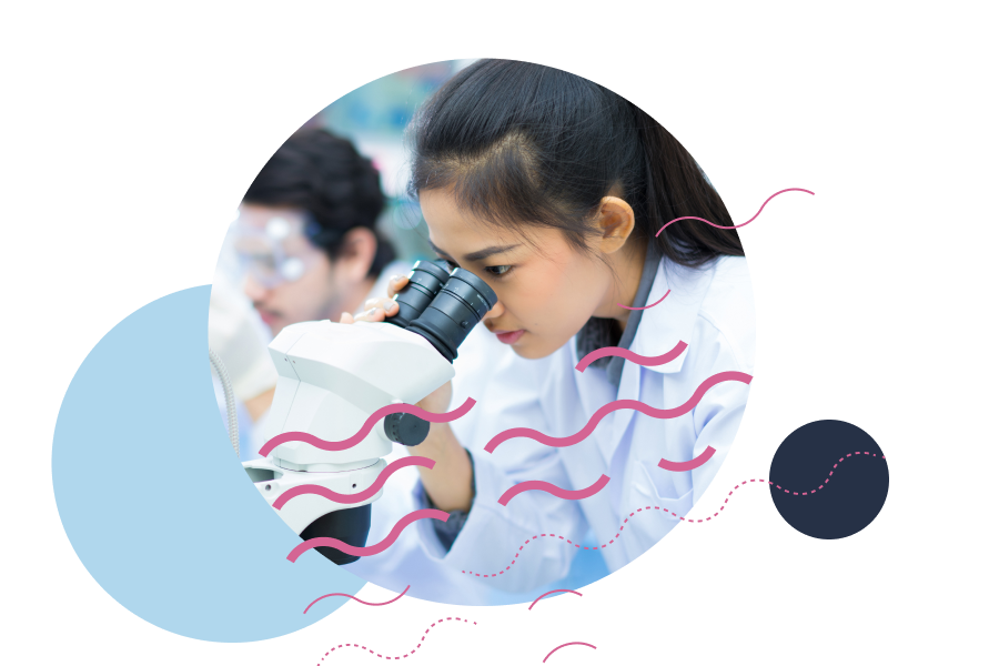 A university student looking through a microscope in a science lab.